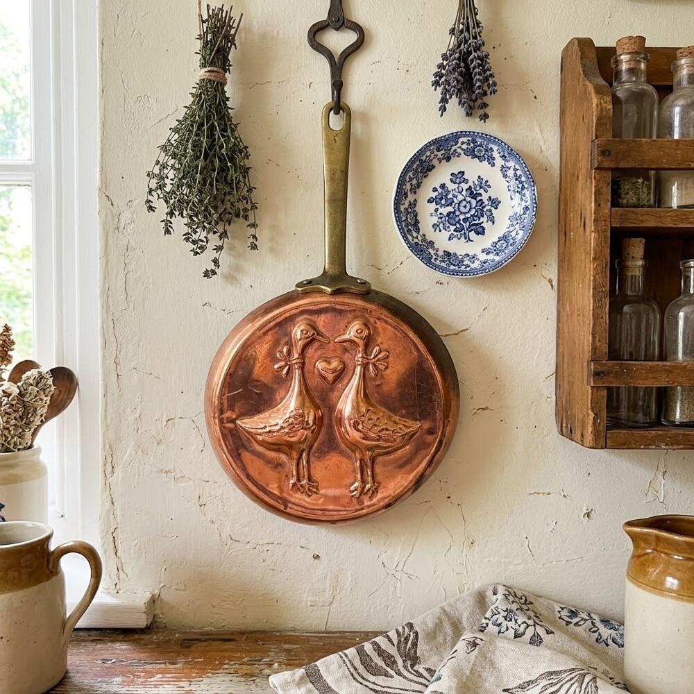 copper pan wall-hanging ducks facing each other heart between them brass handle
